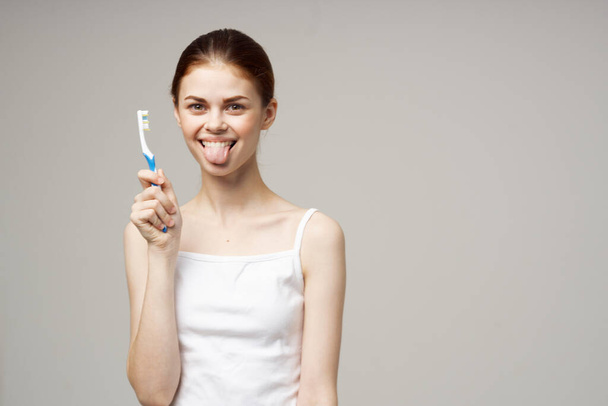 pretty woman toothpaste brushing teeth dental health light background - Fotografie, Obrázek