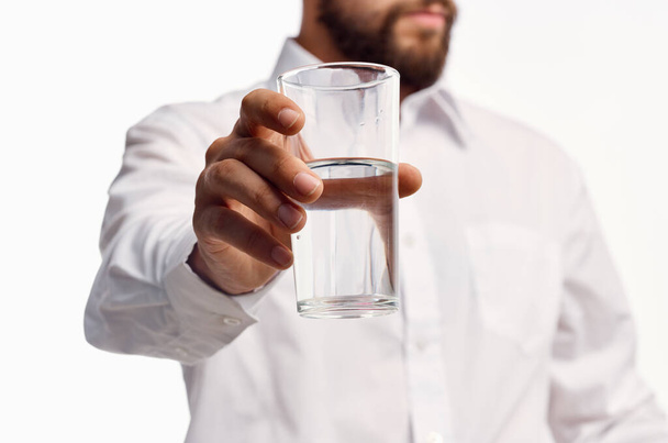 man in wit shirt drinkwater geïsoleerde achtergrond - Foto, afbeelding