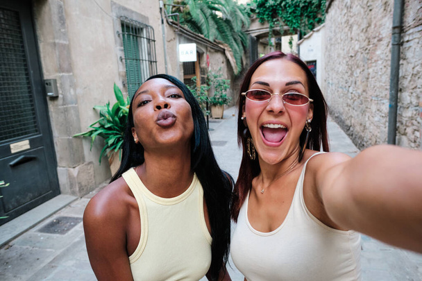 Ženy přátelé brát selfie, zatímco visí spolu procházky po městě. - Fotografie, Obrázek