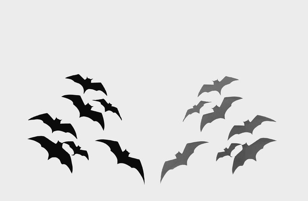 Halloween en decoratie concept, zwart papier vleermuizen vliegen op witte achtergrond - Foto, afbeelding