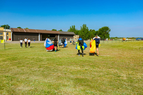 Az ejtőernyősök nyitott ejtőernyős sétát tartanak a reptéren a Nemzeti Ejtőernyős Bajnokságon. - Fotó, kép