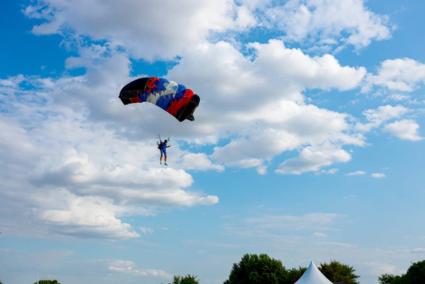 Parachutist it slows down for accurate landing on target place. Skydiving, gliding, parachute jump. - Photo, Image