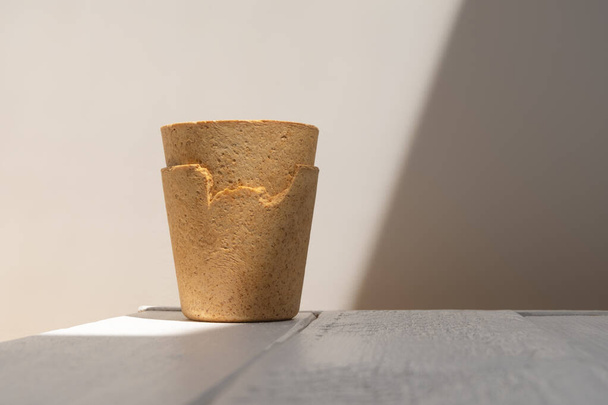 Waffle cups of white wooden table in hard light with creative shadow. New trend of eco-friendly coffee cups - Photo, Image