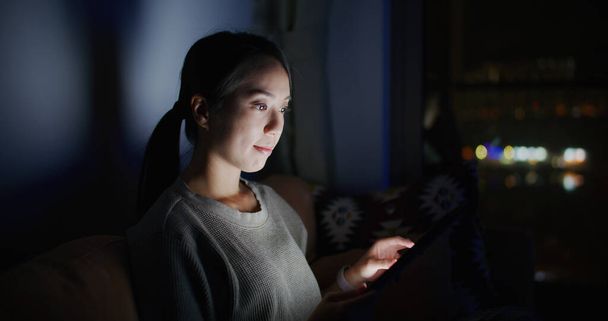 Woman work on tablet computer at home in the evening - Photo, Image