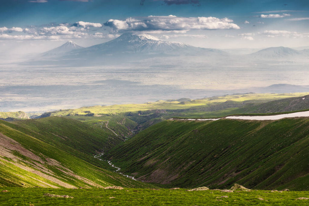 Látványos panoráma nyílik a híres Ararat hegyre Örményországban nyáron. Zöld füves lejtők a szurdok és egy hegyi patak alatt - Fotó, kép