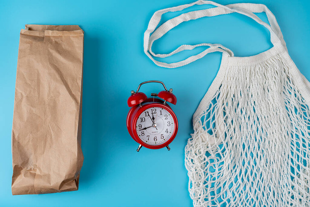 Cotton bags, net bag. Paper bag. Zero waste concept. Eco friendly. Flat lay with a red alarm clock image - Photo, Image