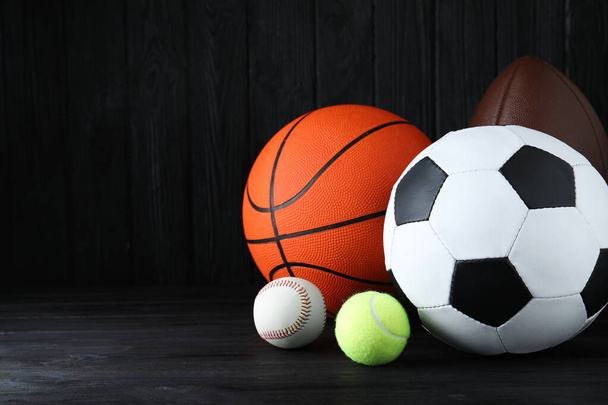 Set of different sport balls on black wooden table. Space for text - Fotoğraf, Görsel