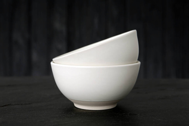 Stylish empty ceramic bowls on black table. Cooking utensils - Fotografie, Obrázek