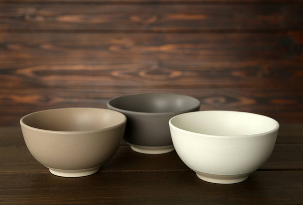 Stylish empty ceramic bowls on wooden table. Cooking utensils - Fotografie, Obrázek