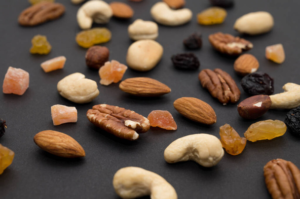 Cashew, Brazil nuts, dried berries, candied fruits on black background. Top view. Healthy vegeterian food. - Photo, Image