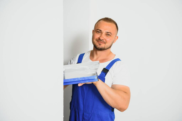 A man processes the wall with a spatula. Plasterer at work. - Valokuva, kuva