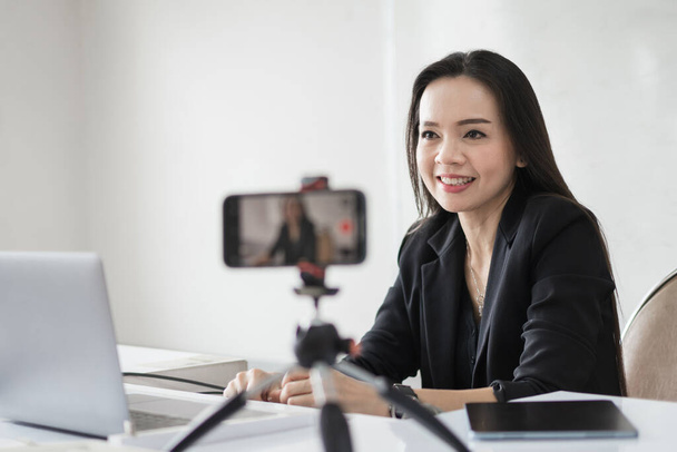 Adult Asian female college teacher teaching online via video conference meeting to students at home. Smiling Asian female tutor having video call with students. - Photo, Image