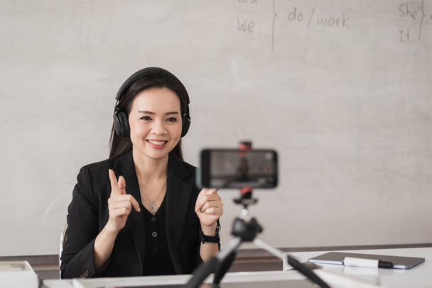 Professora universitária asiática adulta ensinando on-line via videoconferência para estudantes em casa. Sorrindo Asiático tutor feminino ter chamada de vídeo com os alunos. - Foto, Imagem