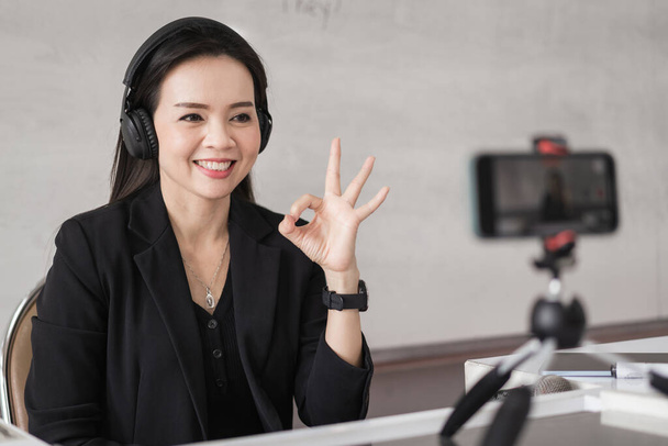 Aikuinen aasialainen naispuolinen college opettaja opettaa verkossa videoneuvottelun kautta opiskelijoille kotona. Hymyilevä aasialainen naisopettaja, jolla on videopuhelu opiskelijoiden kanssa. - Valokuva, kuva