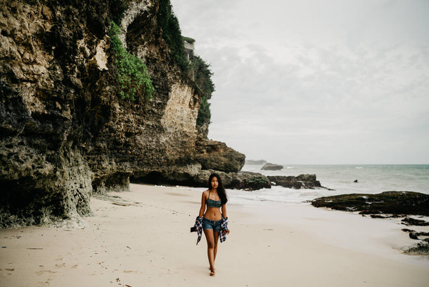Jeune femme en bikini sur la plage - au bord de la falaise - Photo, image