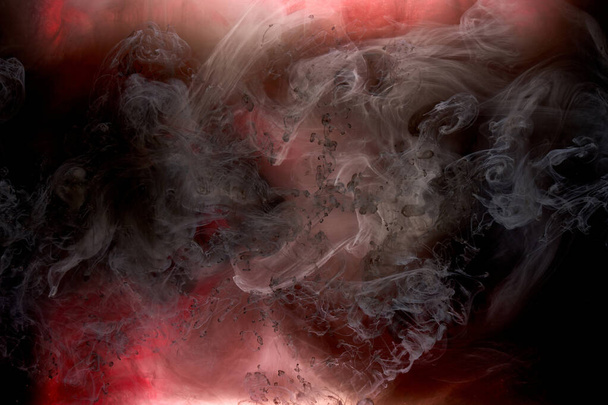 Red black pigment swirling ink abstract background, liquid smoke paint underwater - Foto, Bild