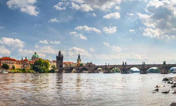 вид на набережную через реку Влтаву на Карлов мост и башню Староместский мост, Прага, Чешская республика - Фото, изображение