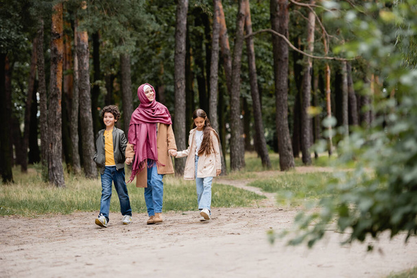 公園を歩くアラビア人の母親と子供たち  - 写真・画像