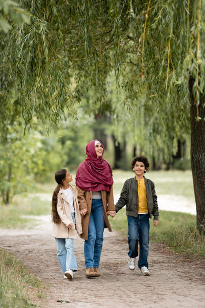 Arab család sétál a fűzfa alatt a parkban  - Fotó, kép