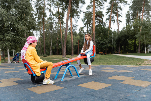 Arabian children playing on playground in park  - 写真・画像