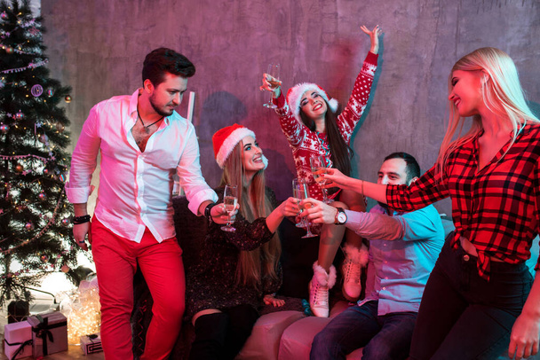 Mladí lidé s brýlemi šampaňského na vánočním večírku - Fotografie, Obrázek