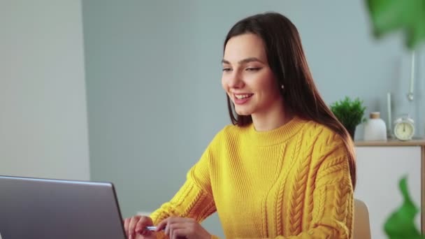Mujer atractiva se comunica por comunicación de vídeo utilizando el ordenador portátil - Imágenes, Vídeo