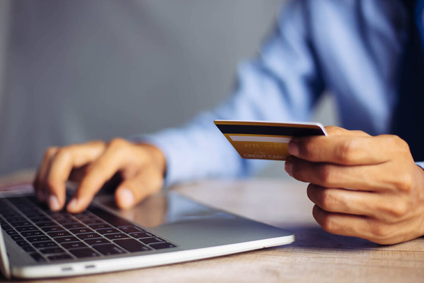 Pagamento online, le mani dell'uomo in possesso di una carta di credito e utilizzando lo smart phone per lo shopping online - Foto, immagini