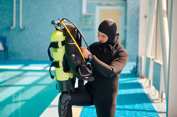Mergulhador masculino coloca no tanque de oxigênio, escola de mergulho - Foto, Imagem