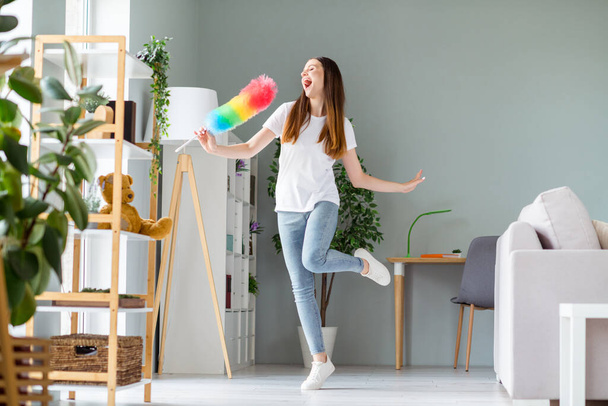 Full length body size view of attractive cheerful carefree girl dancing singing in fluffy brush having fun at home living room indoors - Foto, immagini