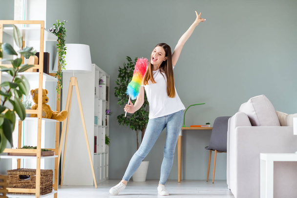 Full length body size view of attractive cheerful funky girl cleansing dust singing in brush having fun at home living room indoors - Foto, afbeelding