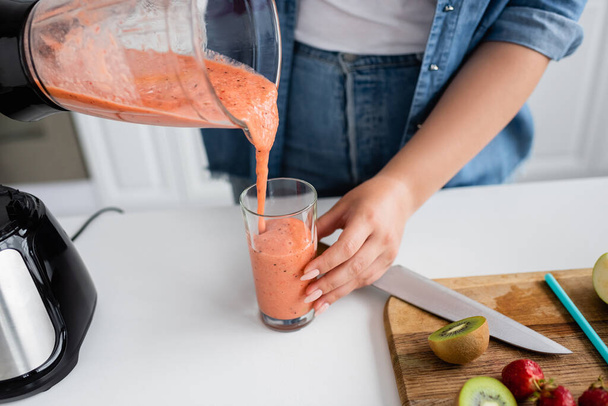 Cropped view of plus size woman pouring smoothie in kitchen  - Photo, Image