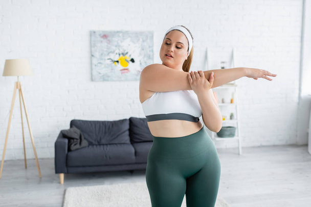 Woman with overweight exercising in living room  - Zdjęcie, obraz