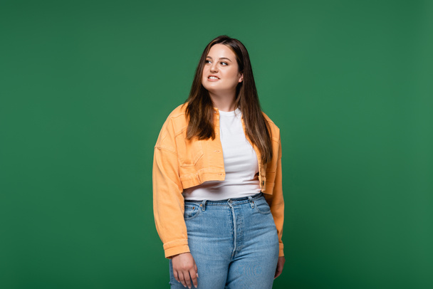 Smiling woman with overweight looking away isolated on green  - Foto, afbeelding