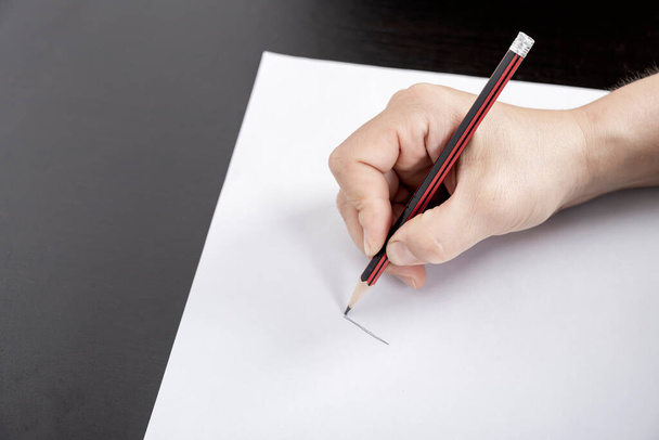 A woman's hand writes on a blank piece of paper - Photo, Image