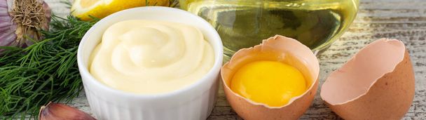 prapor majonézy s česnekem, vejcem, olejem, citronem a bylinkami na bílém dřevěném pozadí - Fotografie, Obrázek