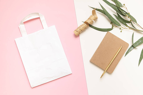 Flat Lay concept de shopping avec sac en papier et feuilles tropicales. Composition élégante avec des accessoires élégants. - Photo, image