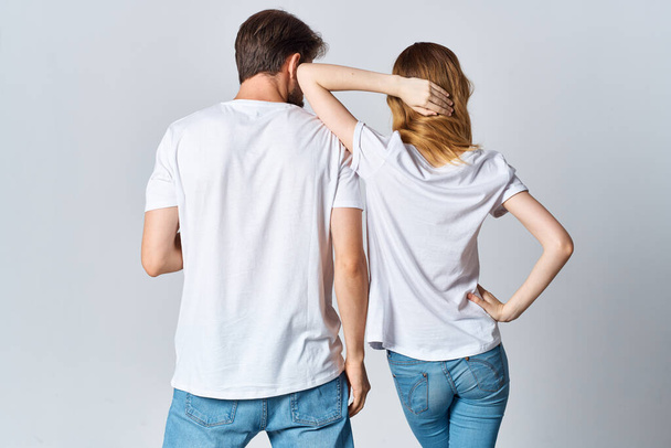 Beyaz tişörtlü ve kot pantolonlu kadın ve erkek gündelik kıyafet modelleri tasarlıyorlar. - Fotoğraf, Görsel