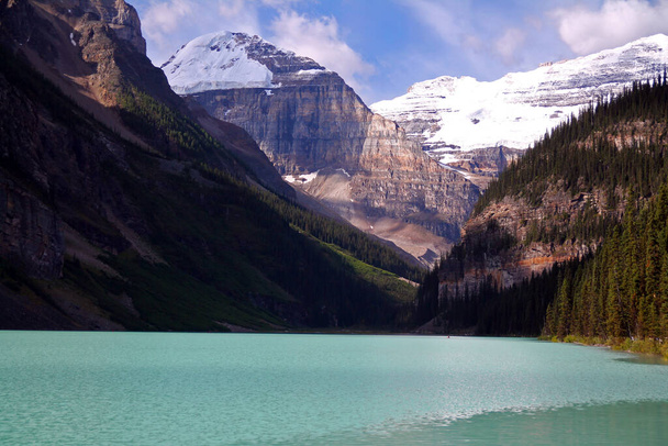 カナダのバンフ国立公園にあるルイーズ湖のターコイズブルーの水の上の雄大な氷河 - 写真・画像