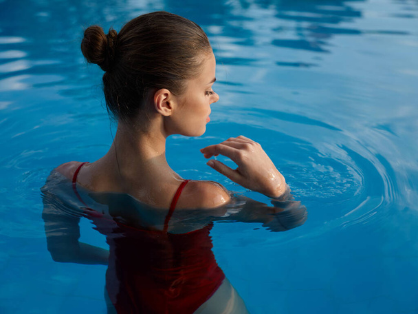 woman in a swimsuit Swimming in the pool luxury vacation back view - Foto, Imagem