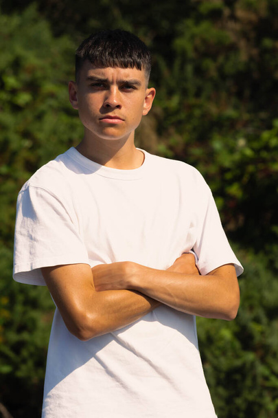 18 year old teen boy in a white t-shirt outdoors with folded arms - Foto, immagini