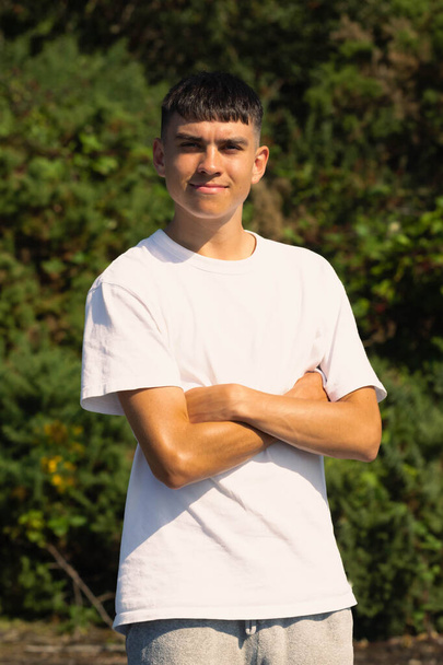 18 year old teen boy in a white t-shirt outdoors with folded arms - Foto, Imagem