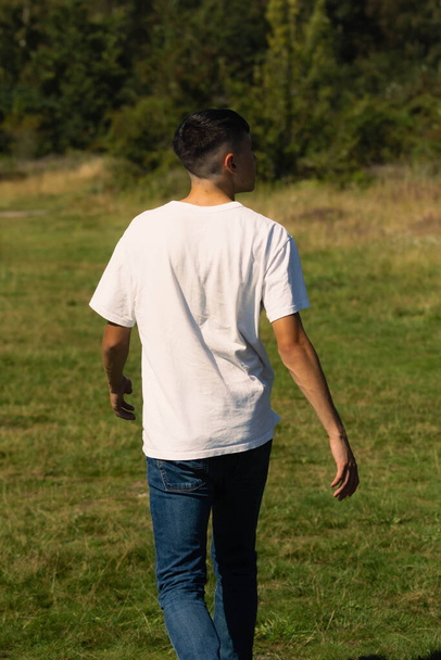 18 year old teen boy in a white t-shirt outdoors and blue denim jeans - Fotografie, Obrázek