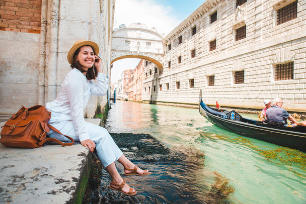 γυναίκα κάθεται στο City Quay στη Βενετία Ιταλία απολαμβάνοντας τη θέα των καναλιών με - Φωτογραφία, εικόνα