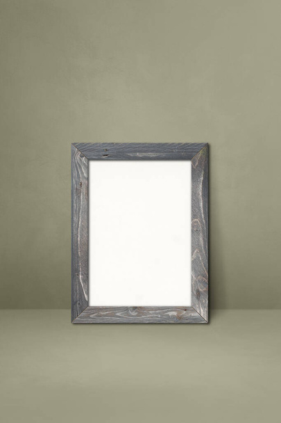 Wooden picture frame leaning on a grey wall. Blank mockup template - Foto, Bild