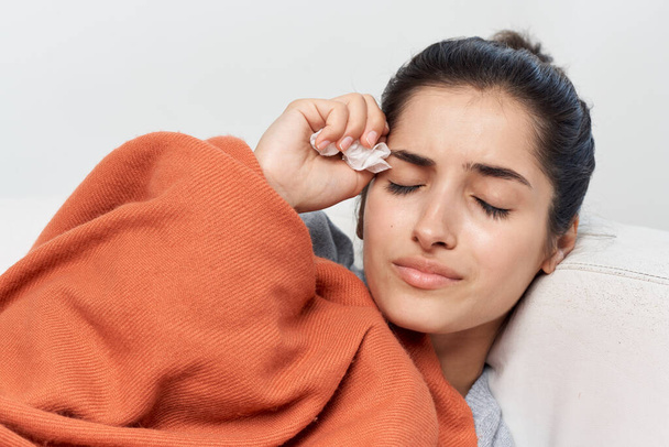 Frau liegt auf dem Sofa mit einer Decke bedeckt Erkältung gesundheitliche Probleme Grippe - Foto, Bild