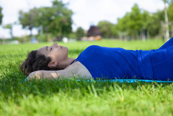 Young woman lying down on the grass resting peacefully - Fotografie, Obrázek