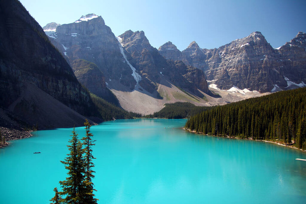 Τα γαλαζοπράσινα νερά της λίμνης Moraine και οι κορυφές γύρω από αυτό στο Banff National Park στον Καναδά - Φωτογραφία, εικόνα