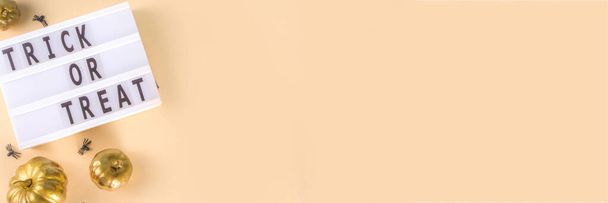 Трюк або ласощі фону, Проста вітальна листівка на Хеллоуїн, запрошення на вечірку абстрактна квартира з золотими кольоровими гарбузами, зірками, павуками, на бежево-жовтому фоні копіювання простору зверху
 - Фото, зображення