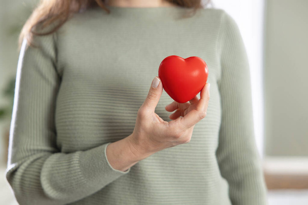 Young woman holding red heart, organ donation, medicine day, heart health week or valentine's day concep - Foto, Imagem