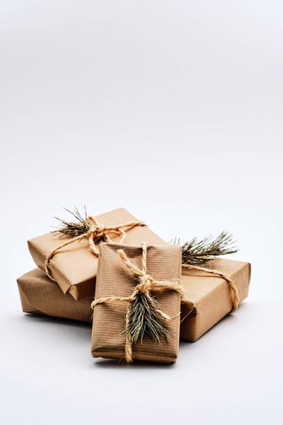 Beyaz arka planda Kraft kağıdına sarılı Noel hediyesi paketleri - Fotoğraf, Görsel